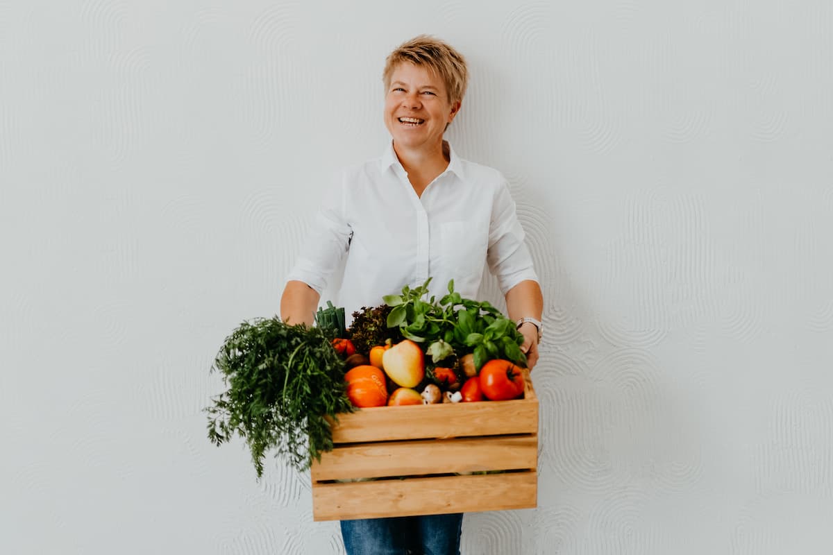 Jacqueline Näther-Piatraschk mit einer Kiste voller Gemüse